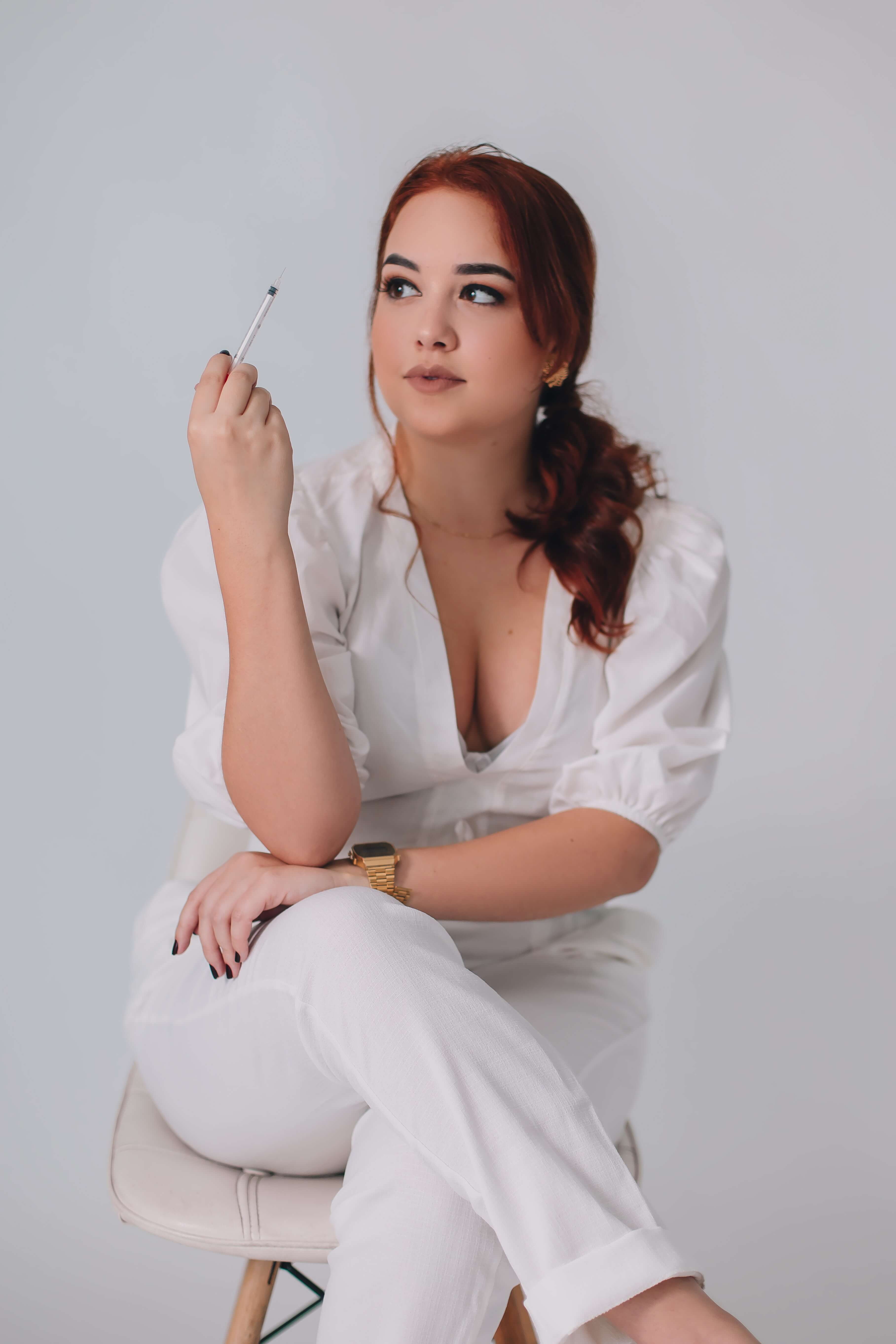 Woman holding syringe, aesthetic injector, medical director collaboration, Injectables EDU training.